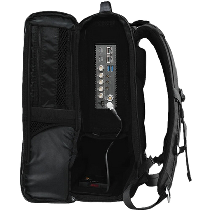 An open black Teradek Prism backpack shown from the inside, revealing a built-in multi-port power bank or charging station with USB-A, USB-C, and other connectors on the back panel.
