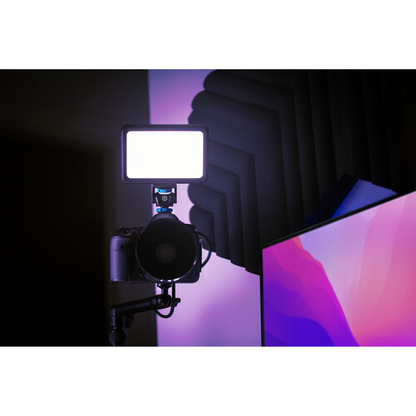 Camera with light modifier in a dark room with colorful screen
