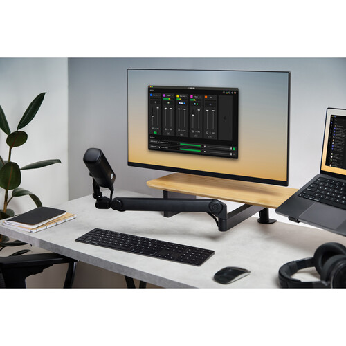 Modern home office setup with a computer monitor, keyboard, mouse, and laptop on a desk.
