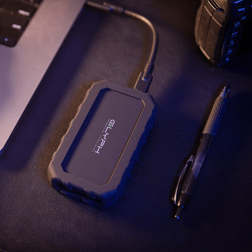 Blue external hard drive on a desk with a pen and phone in the background