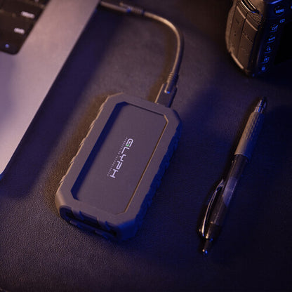 Blue external hard drive on a desk with a pen and phone in the background
