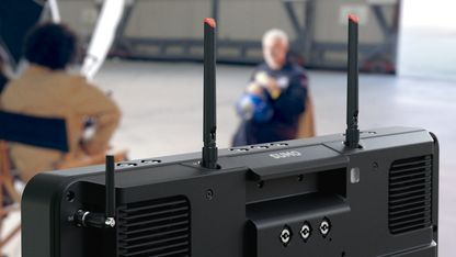 Back view of a black electronic device with antennas in an indoor setting.
