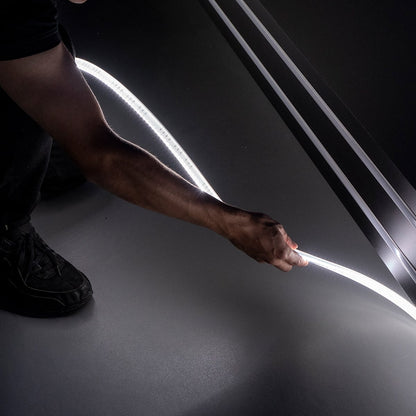 Person holding a strip of LED light against a car door