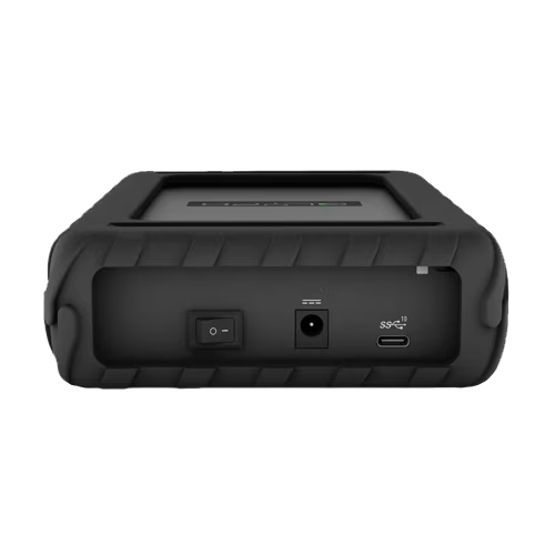 A rugged black portable media hard drive shown from the back, featuring a textured rubberized grip, a power switch, a USB-C port, and a USB-A port on a plain white background.