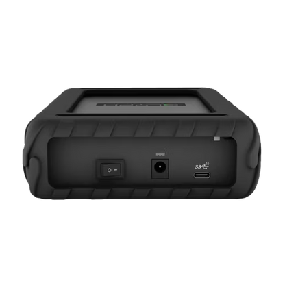 A rugged black portable media hard drive shown from the back, featuring a textured rubberized grip, a power switch, a USB-C port, and a USB-A port on a plain white background.