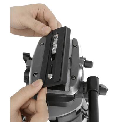 Close-up of a person adjusting a camera mount on a tripod with a white background