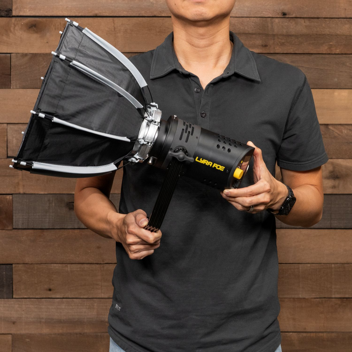 Person holding a black light fixture against a wooden background