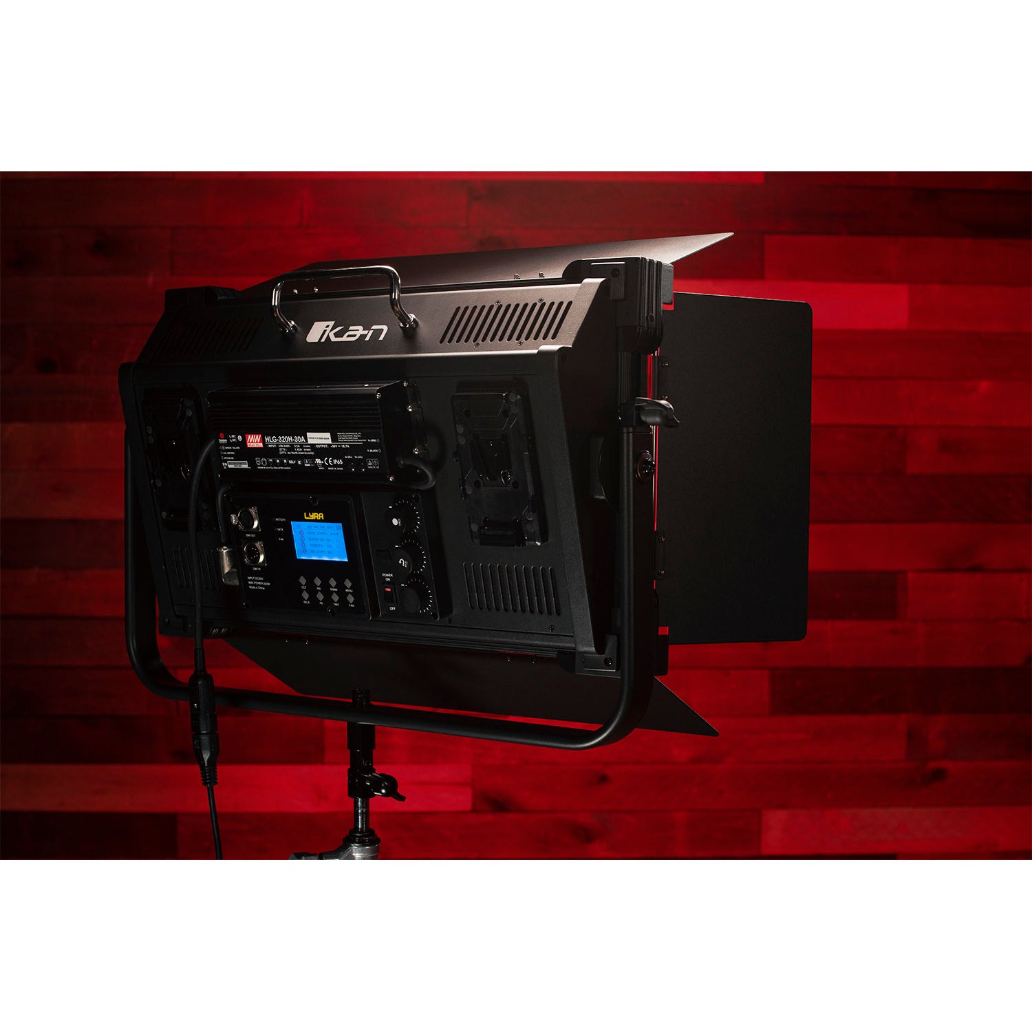 Black studio light with brand logo on a red background