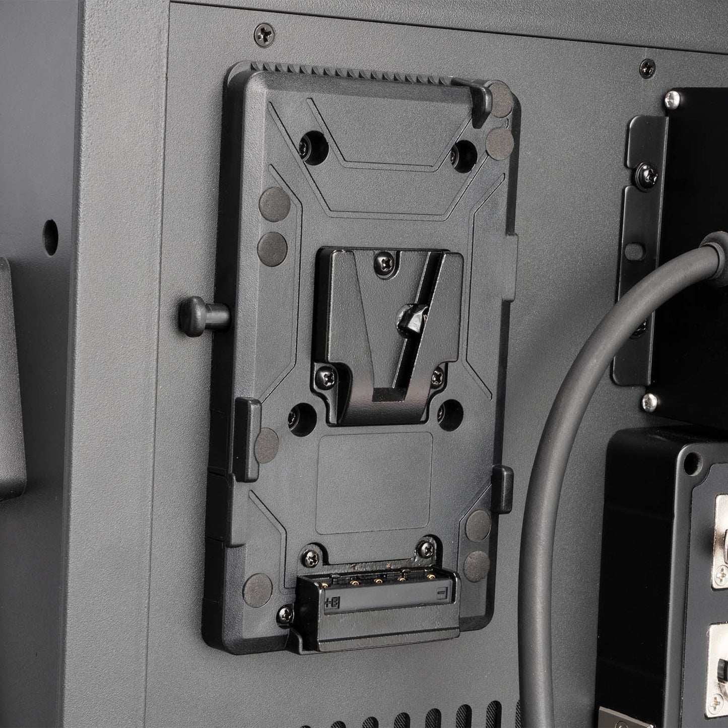 Metal bracket or mount on a gray surface with cables and hardware visible.