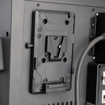 Metal bracket or mount on a gray surface with cables and hardware visible.