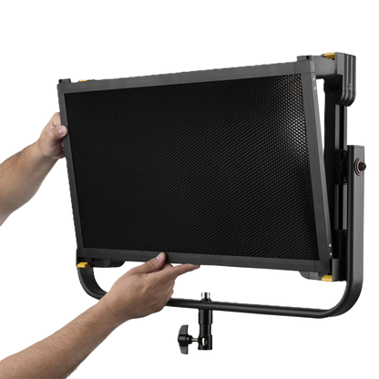 Person holding a large black screen with a grid pattern on a white background