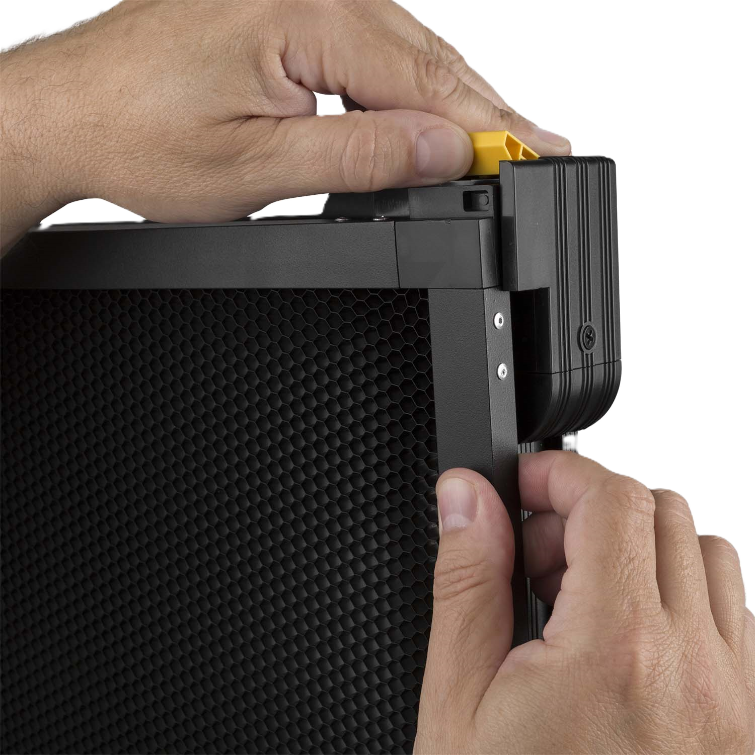 Close-up of hands attaching a black electronic device with textured surface