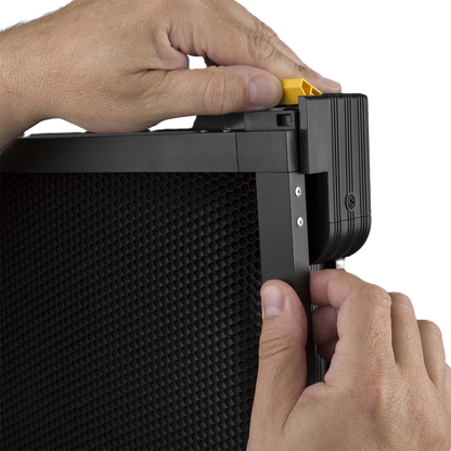 Close-up of hands attaching a black electronic device with textured surface