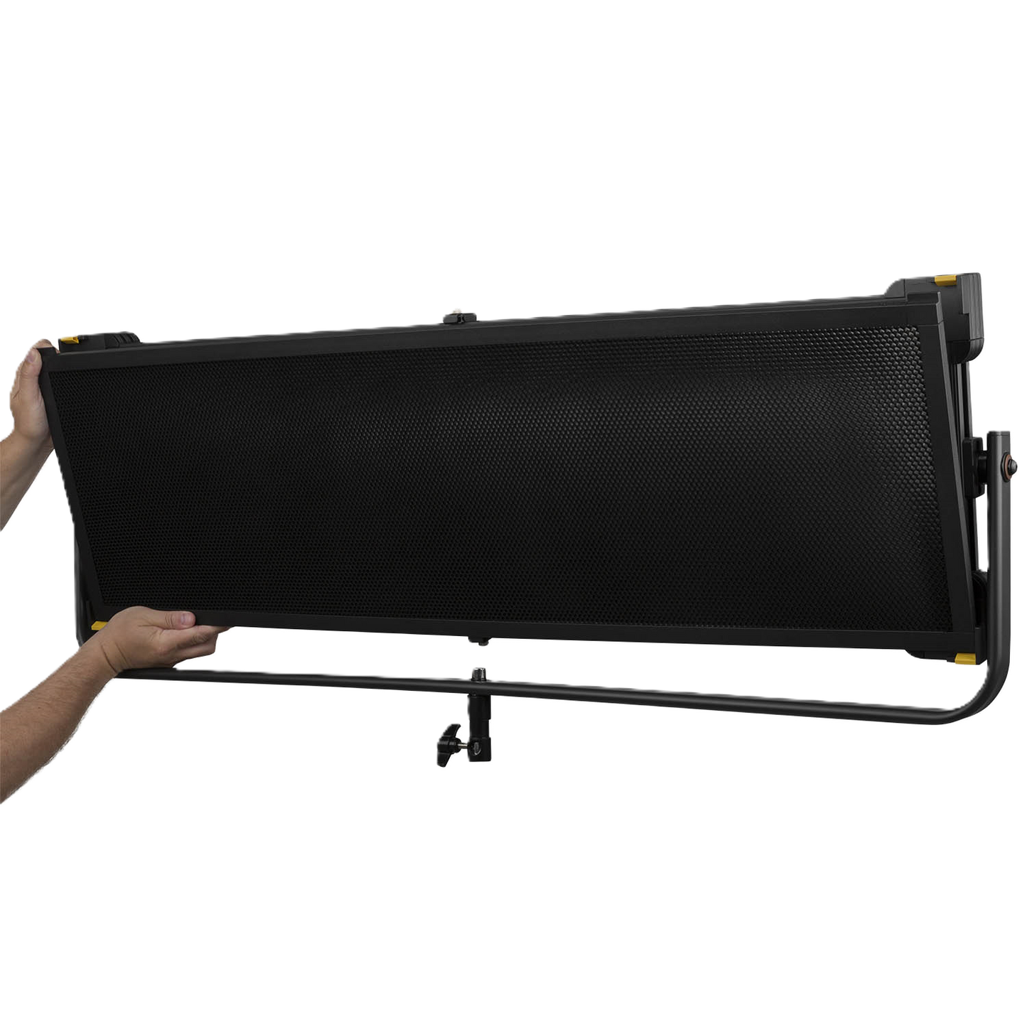 Black studio light with stand held by a person on a white background