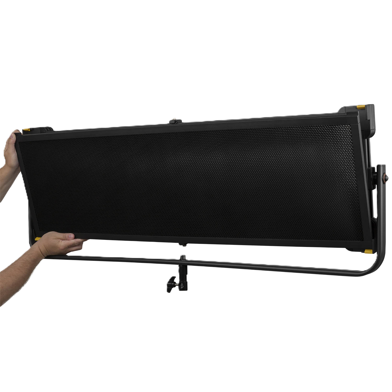 Black studio light with stand held by a person on a white background