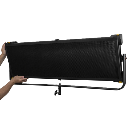 Black studio light with stand held by a person on a white background