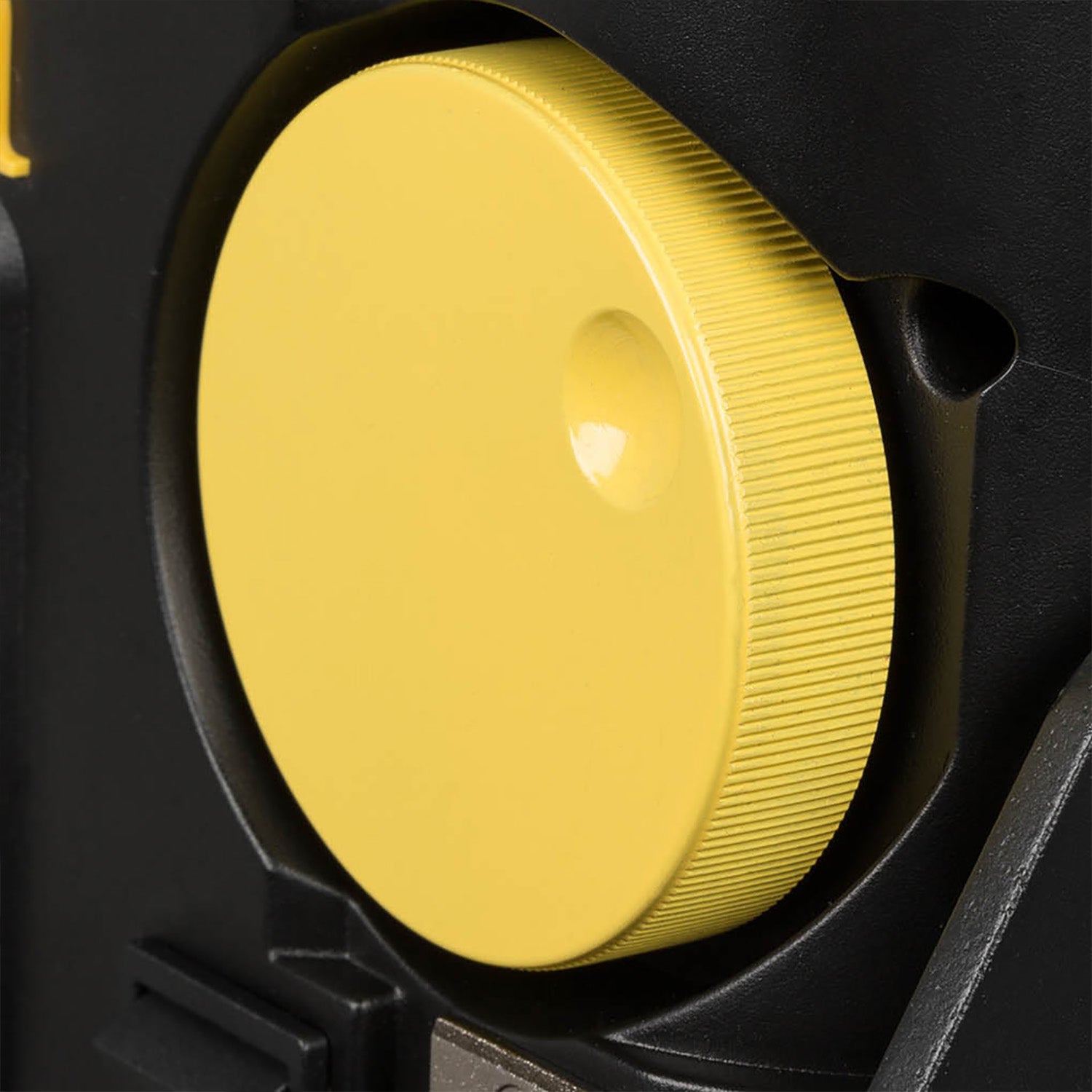 Close-up of a yellow circular object inside a black mechanical component