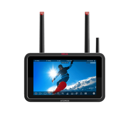 ATOMOS Ninja TX monitor with screen displaying a person on a surfboard against a blue sky, with two antennas on a black background.