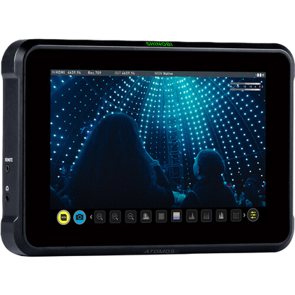 Display device with screen showing a silhouette of people in front of a bright light display, branded 'Atomos'.