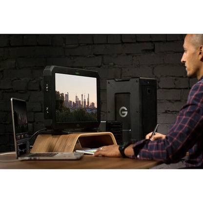Person using a computer setup with multiple monitors in a dark room.